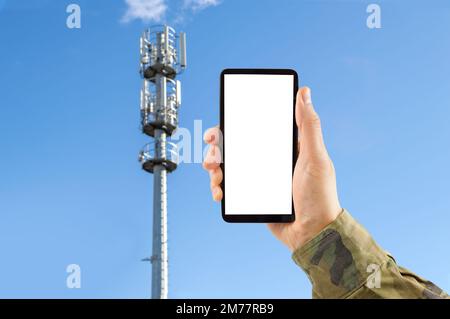 5G military communication tower with man using mobile smart phone Stock Photo