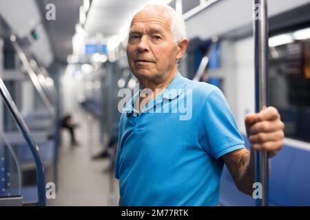 Elderly man in subway train Stock Photo