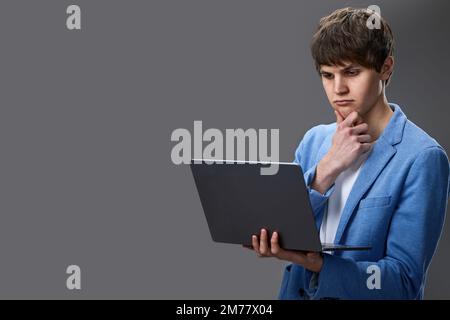 caucasian young man using laptop isolated on gray background Stock Photo
