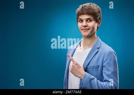 young man in jacket pointing at copy space Stock Photo