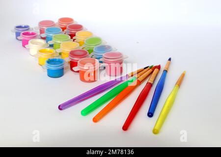 Colorful paintbrushes and mini pots of paint depicting a painting craft concept with kids Stock Photo