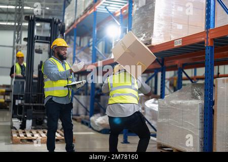 African american working in warehouse got accident from carry box, forklift truck working near by Stock Photo