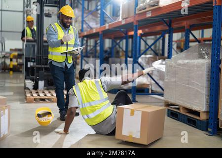 African american working in warehouse got accident from carry box, forklift truck working near by Stock Photo