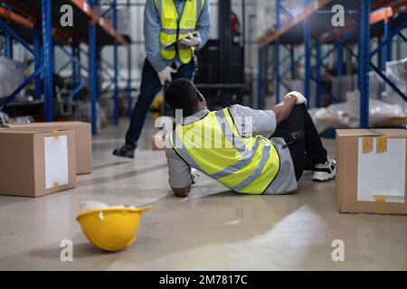 African american working in warehouse got accident from carry box, forklift truck working near by Stock Photo