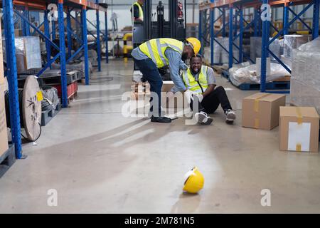 African american working in warehouse got accident from carry box, forklift truck working near by Stock Photo