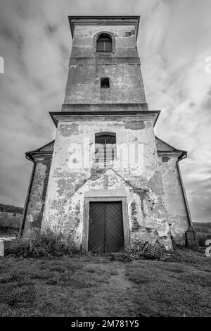 Vertical shot of old Church of Saint John of Nepomuk falling apart on a warm cloudy day of winter. Black and white image with dramatic low angle Stock Photo