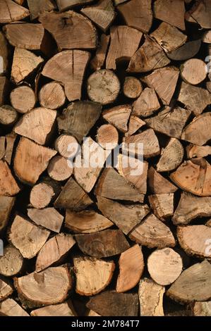 Stack of cut firewood logs arranged for storage and heating in vertical format Stock Photo