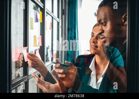 Business people in office work together analyzing data and graphs Stock Photo