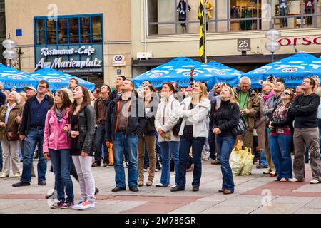 A crowd gazes up at the Glockenspiel in Marienplatz, Munich, Germany. Stock Photo