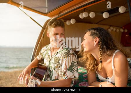 Affectionate young couple at camper van in rural landscape Stock Photo ...