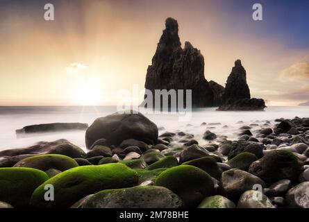 Sunrise in rocky coast with monumental rocky cliff and blurred sea water. Madeira island, Portugal Stock Photo