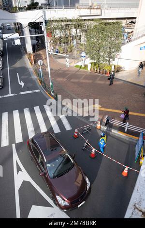 Tokyo, Japan. 6th Jan, 2023. A flagger waves through vehicle traffic past road construction outside a Marunouchi Line train station at Metro M Korakuen Station, which includes a shopping mall in the station that trains pull into. (Credit Image: © Taidgh Barron/ZUMA Press Wire) Stock Photo