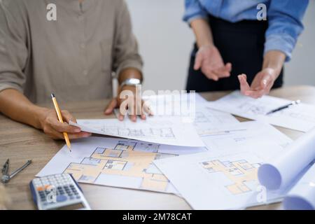 Concept of engineering consulting, Two female engineers discussing about blueprint of condominium. Stock Photo