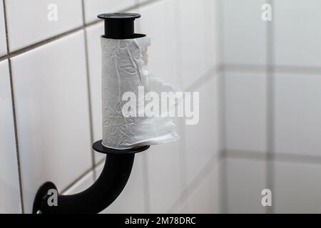 Last pad of tissue paper on background - Toilet Paper Holder Stock Photo