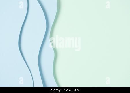 Abstract colored paper texture background. Minimal paper cut composition with layers of geometric shapes and lines in light blue color on green color Stock Photo