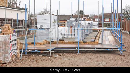 Specialist scaffolding contractor commences building of safe scaffold working platform for house builder bricklayers & other tradesmen England UK Stock Photo