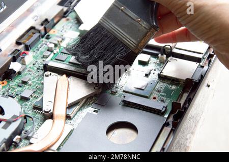 technician using brush Clean dusty notebooks. Stock Photo