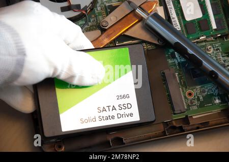 Technician installing ssd drive in old computer, upgrading computer Stock Photo