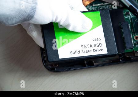 Technician installing ssd drive in old computer, upgrading computer Stock Photo