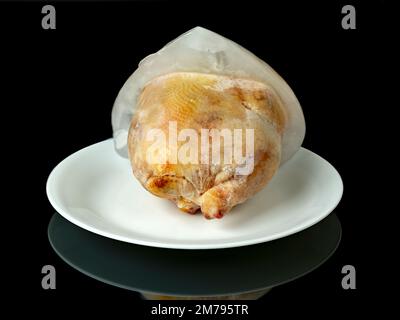 Ice attached to a game hen on a white plate Stock Photo