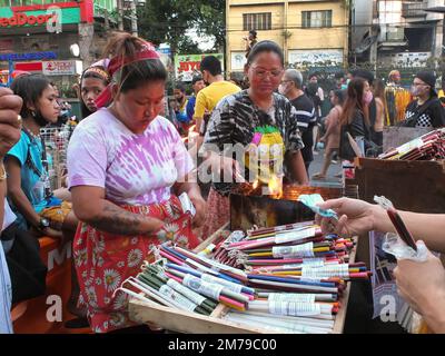 Manila, Philippines. 08th Jan, 2023. A vendor busy selling candles outside the Quiapo Church. Catholic devotees flock to Quiapo Church in Manila to express their devotion to the Black Nazarene, a life-sized image of dark skinned, kneeling Jesus Christ carrying the cross. A day before it's feast on January 9. This festive activity was put on hold for two years because of the COVID-19 pandemic. (Photo by Josefiel Rivera/SOPA Images/Sipa USA) Credit: Sipa USA/Alamy Live News Stock Photo