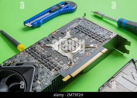 Open graphics card showing chips, MOSFETs, and power section. Clear view of components on PCB. Tools beside Stock Photo