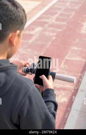 young man on an electric skate using smartphone gps applications Stock Photo