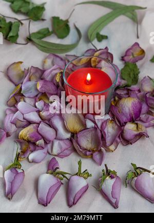 Dried roses, candle and book on a cloth Stock Photo