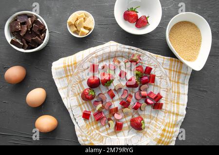 Summer fruit cake preparation. Baking tart or pie with strawberry or rhubarb, top view. Stock Photo
