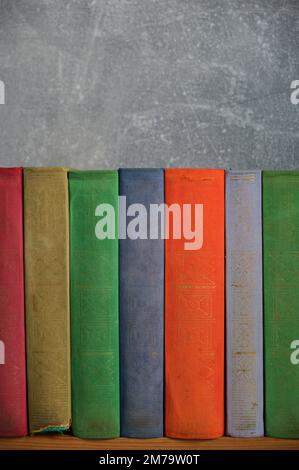 Home library of old battered retro books with colored spines Stock Photo