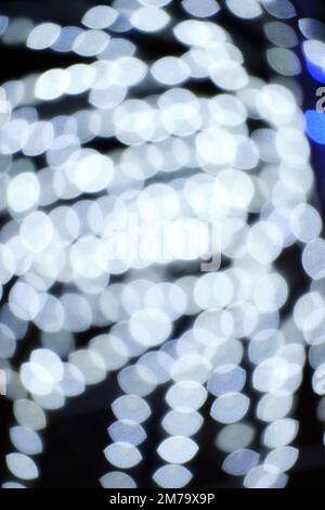 Background, bokeh blurred light from garlands burning with white light Stock Photo