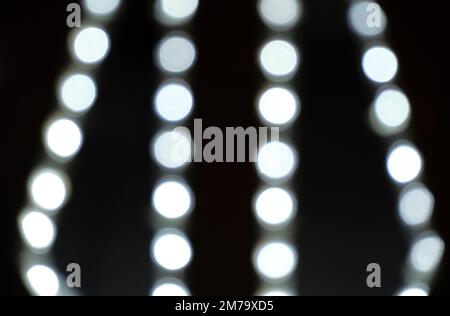 Background, bokeh blurred light from garlands burning with white light Stock Photo