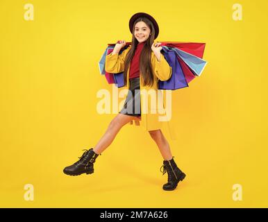 Autumn shopping sale. Happy teenager portrait. Stylish teen girl with shopping sale bags. Kid holding purchases. Fashion style of trendy child Stock Photo