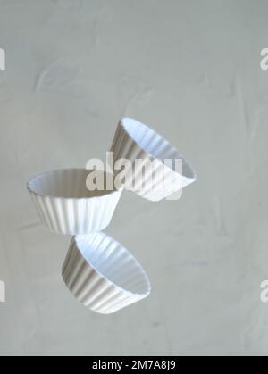 Flying white bowls in levitation on air Stock Photo