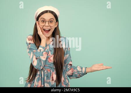 Look at advert. Teenager child points aside shows blank copy space for text promo idea presentation, poses. Excited teenager, amazed and cheerful Stock Photo