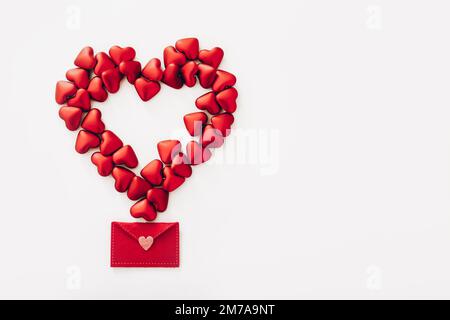 Big heart made from small red hearts and felt envelope on white background, top view Stock Photo