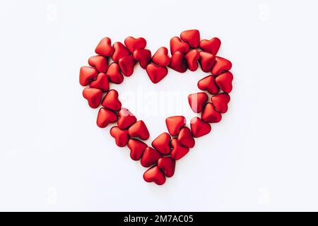 Big heart made from small red plastic hearts on white background, top view Stock Photo