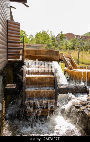 The swirling water turns the wooden wheel of an approximately 200-year-old water mill in Transylvania, which has been restored. Stock Photo