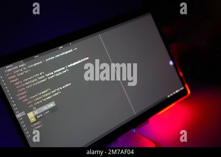 Writing computer code displayed on monitor neon red back light Stock Photo