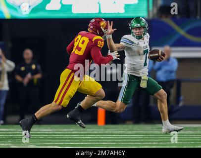 Arlington, TX, USA. 2nd Jan, 2023. Tulane Green Wave quarterback Michael Pratt (7) extends the stiff arm, as he is hotly pursued by Trojans defensive end (99) Nick Figueroa during the Goodyear Cotton Bowl game between the Tulane Green Wave and the University of Southern California Trojans on January 2, 2023 at AT&T Stadium in Arlington, Texas. (Mandatory Credit: Freddie Beckwith/MarinMedia.org/Cal Sport Media) (Absolute Complete photographer, and credits required).Television, or For-Profit magazines Contact MarinMedia directly. Credit: csm/Alamy Live News Stock Photo