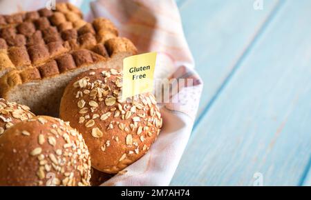 Gluten free label on basket of freshly baked bread and buns. Copy space. Stock Photo
