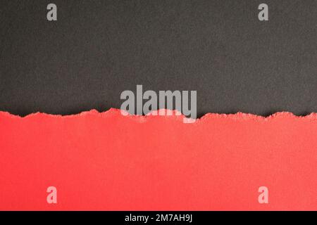 Torn half sheet red paper horizontal on dark grey paper. As template for message or advertisement. Stock Photo