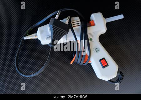 Electric hot glue gun isolated on black background Stock Photo