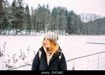 portrait of a woman in winter clothes on the nature. There is a