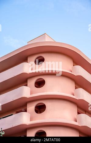 Honolulu, Hawaii - January 1, 2022: Exterior of a pink, retro art deco style apartment building in the heart of Waikiki. Stock Photo