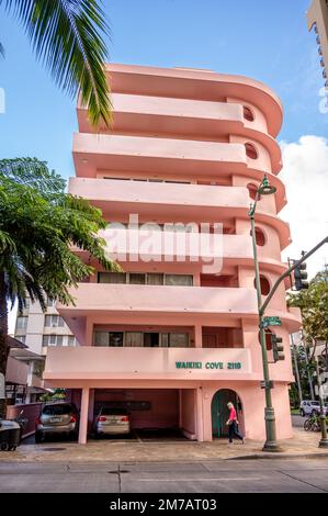 Honolulu, Hawaii - January 1, 2022: Exterior of a pink, retro art deco style apartment building in the heart of Waikiki. Stock Photo