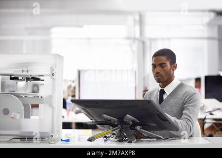 Perfection at his fingertips. a young man working on his computer. Stock Photo