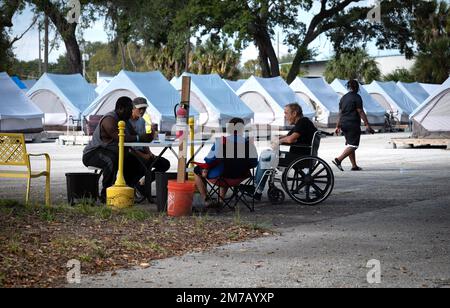 Tampa, Florida, USA. 30th Dec, 2022. Residents at Tampa Hope shelter pass the time chatting at a table near the tents. (Credit Image: © Robin Rayne/ZUMA Press Wire) Stock Photo