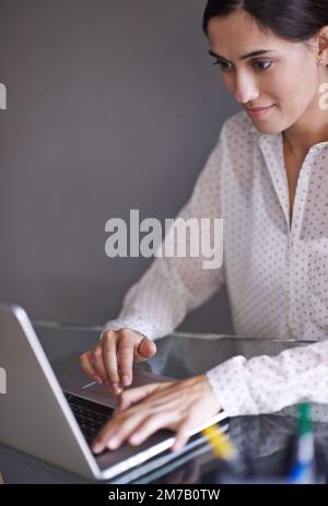 Focused on the work. a beautiful young woman working on her laptop from home. Stock Photo