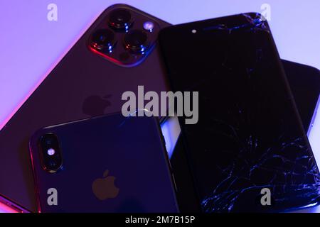 South Tyrol, Italy - Jan. 7. 2023: Broken Apple iPhone display on top of iPhone X and iPhone 13 Pro. Repairing Smartphones Stock Photo